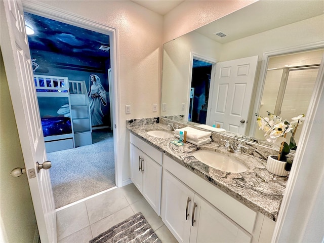 full bath featuring a shower stall, double vanity, tile patterned flooring, and a textured wall