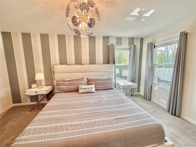 carpeted bedroom featuring baseboards, wallpapered walls, and a textured ceiling