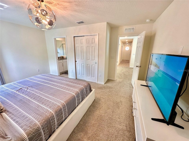 bedroom featuring light colored carpet, a closet, a textured ceiling, and baseboards