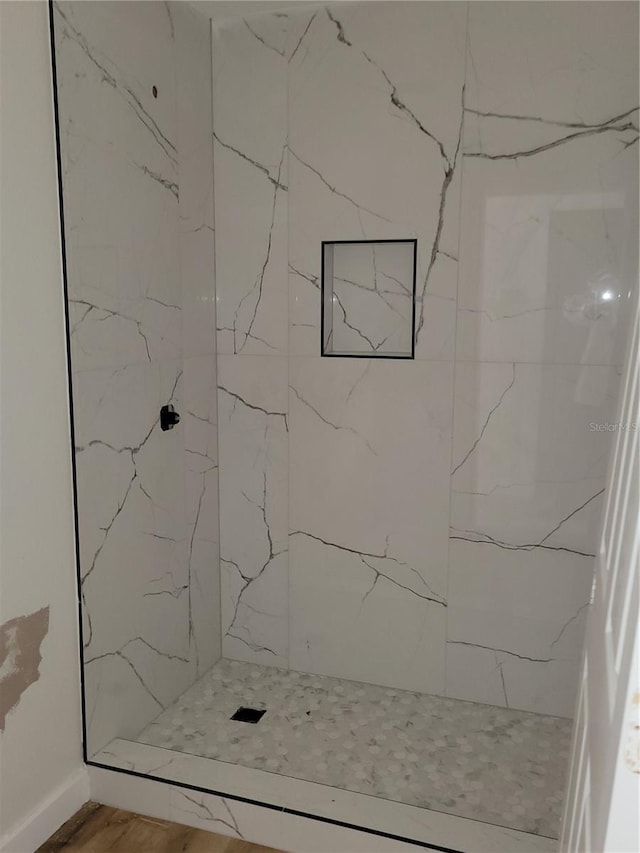 full bathroom with a marble finish shower