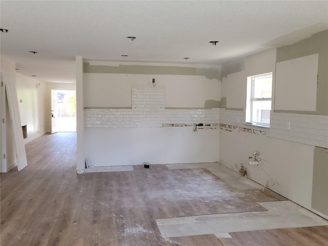 kitchen with healthy amount of natural light, light wood-type flooring, and tasteful backsplash