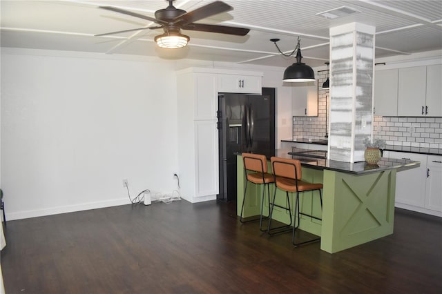 821 Silver Springs Ter NW, Port Charlotte, FL 33948 - kitchen with black fridge with ice dispenser, dark countertops, backsplash, a ceiling fan, and a kitchen bar