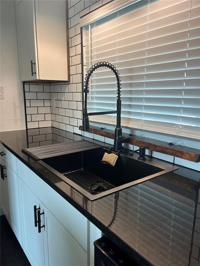 821 Silver Springs Ter NW, Port Charlotte, FL 33948 - kitchen view of a sink, decorative backsplash, and white cabinetry