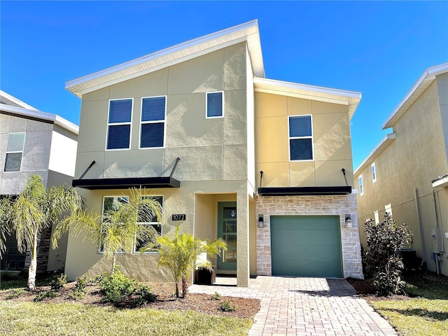 1077 Leader St, Davenport, FL 33896 - view of front of house featuring an attached garage, stone siding, stucco siding, and driveway