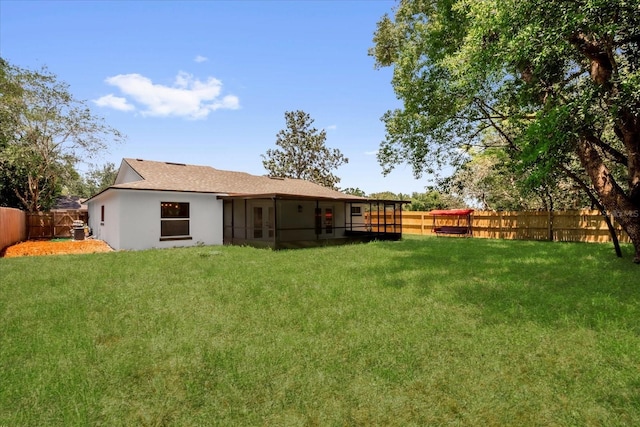 rear view of house with a sunroom and stucco siding