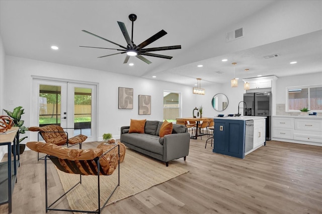 living room with french doors, light wood finished floors, recessed lighting, and a ceiling fan
