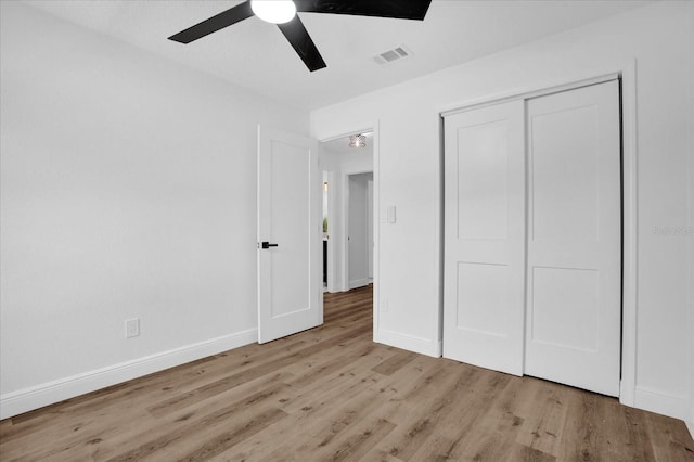 unfurnished bedroom with light wood-style flooring, baseboards, ceiling fan, and a closet