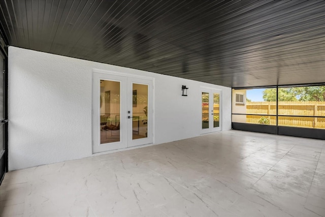 unfurnished sunroom with french doors