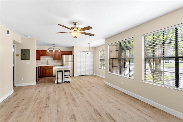 325 Forestway Cir Unit 104, Altamonte Springs, FL 32701 - unfurnished living room with electric panel, ceiling fan, baseboards, light wood-style floors, and a sink