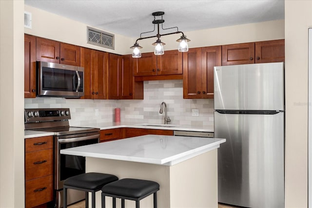325 Forestway Cir Unit 104, Altamonte Springs, FL 32701 - kitchen featuring appliances with stainless steel finishes, a sink, backsplash, light countertops, and a kitchen breakfast bar