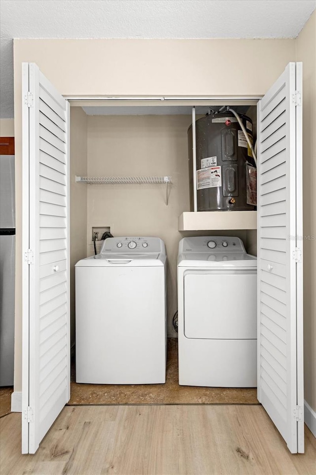 325 Forestway Cir Unit 104, Altamonte Springs, FL 32701 - clothes washing area with wood finished floors, washing machine and dryer, and water heater