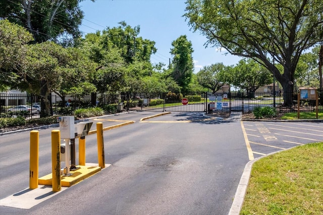 325 Forestway Cir Unit 104, Altamonte Springs, FL 32701 - view of asphalt road with a gated entry, curbs, and traffic signs