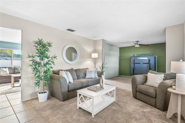 carpeted living area with a ceiling fan
