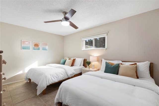 bedroom featuring tile patterned flooring, a ceiling fan, and a textured ceiling