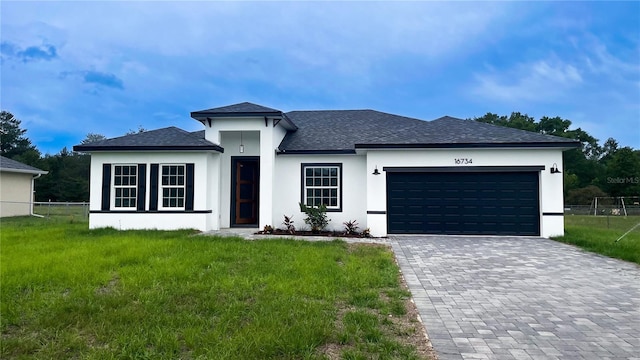 view of front of house with a shingled roof, stucco siding, a garage, and decorative driveway