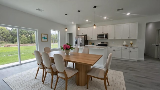 dining area featuring baseboards and light wood-style flooring