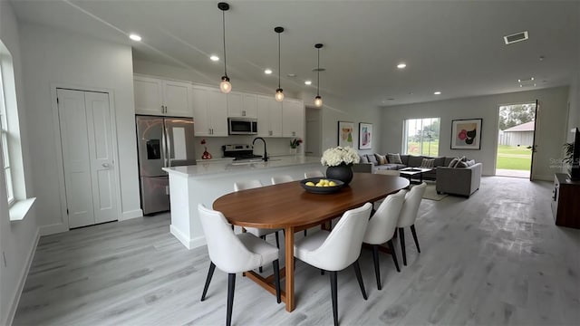 dining space with light wood-type flooring, recessed lighting, and baseboards