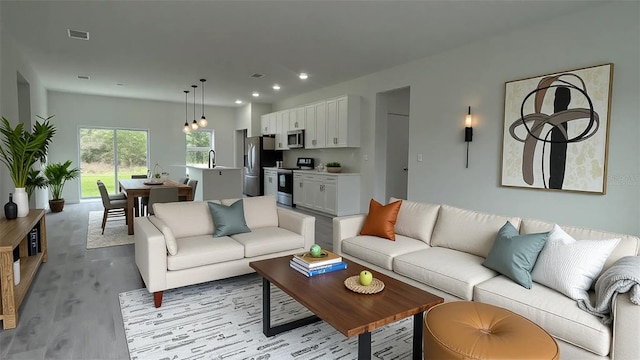 living room with light wood finished floors and recessed lighting