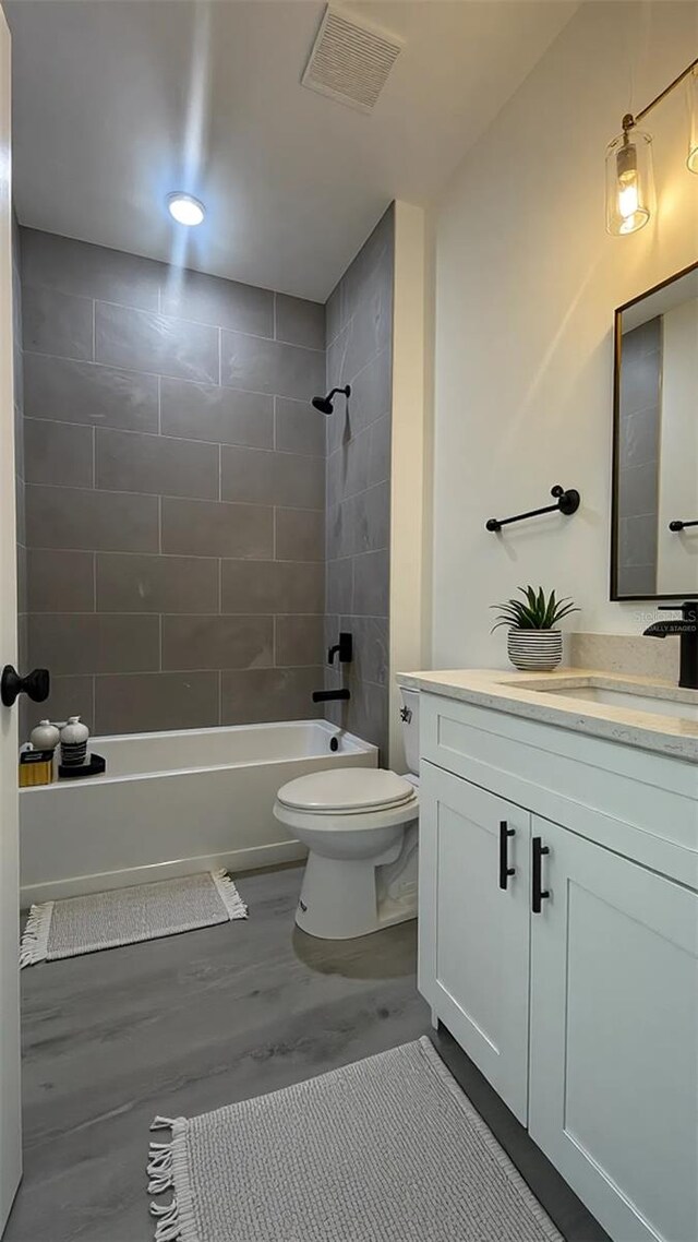 bathroom with toilet, tub / shower combination, and vanity