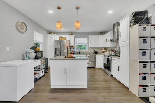 300 Hickory Ct, Apopka, FL 32712 - kitchen featuring stainless steel appliances, wall chimney exhaust hood, decorative backsplash, white cabinets, and recessed lighting