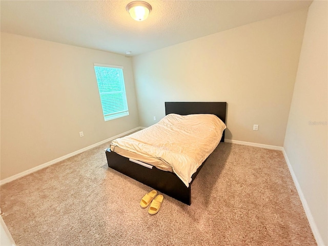 bedroom featuring carpet flooring, baseboards, and a textured ceiling