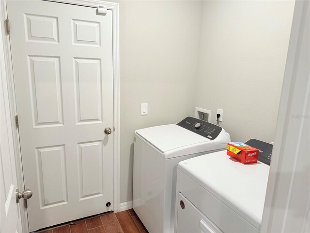 washroom featuring washer and dryer, dark wood-style floors, and baseboards