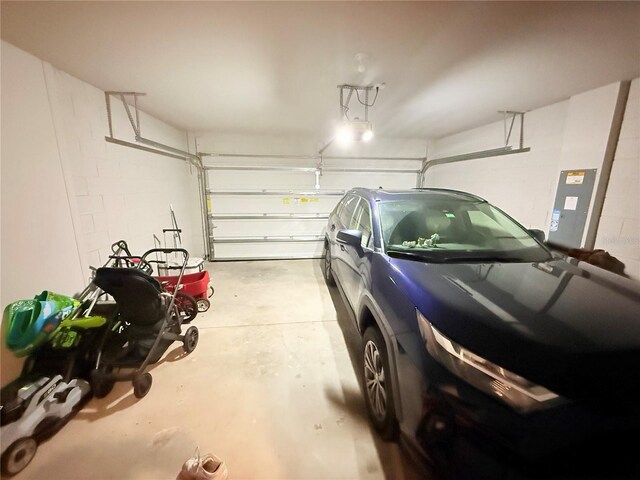garage featuring electric panel and concrete block wall