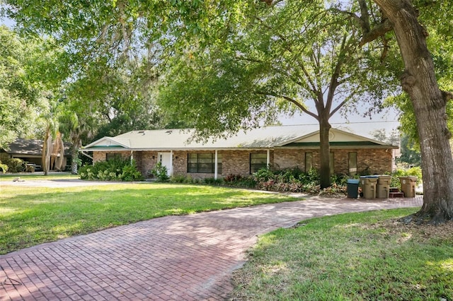 ranch-style house featuring brick siding and a front lawn