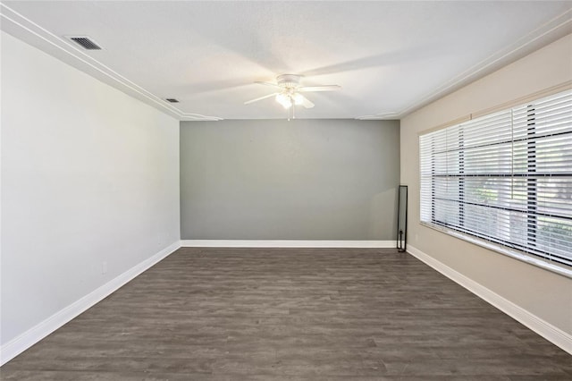 empty room featuring a ceiling fan, dark wood-style floors, and baseboards