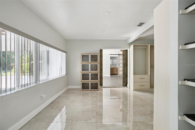 empty room featuring baseboards and marble finish floors