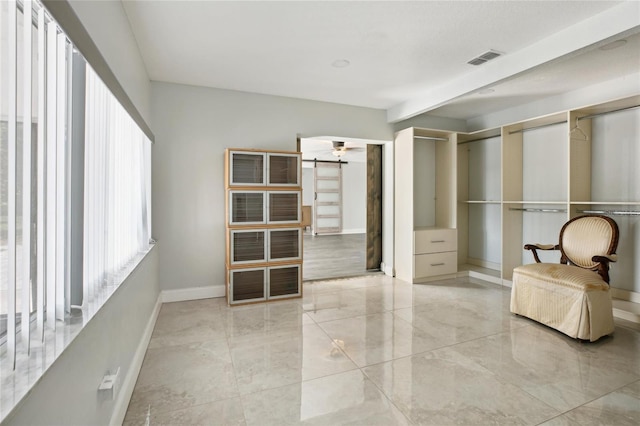 bedroom with baseboards, multiple closets, beam ceiling, and marble finish floors