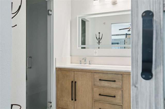 bathroom with vanity, ceiling fan, and a shower stall