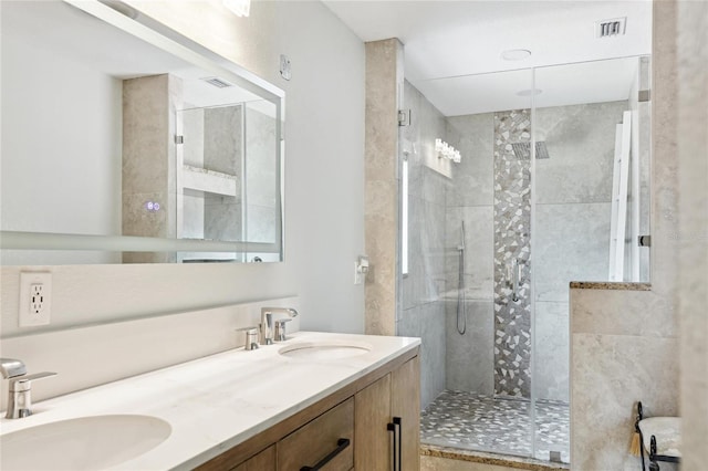 bathroom featuring a shower stall and double vanity