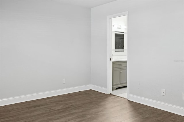 unfurnished room with dark wood-style flooring and baseboards