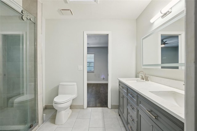 bathroom with toilet, a stall shower, baseboards, tile patterned floors, and double vanity