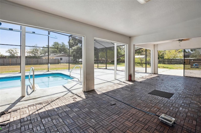 view of pool with a patio area, fence, and glass enclosure