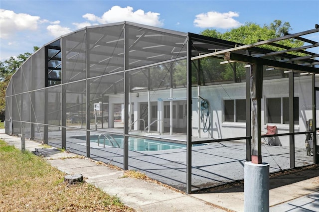 outdoor pool with a patio area and glass enclosure