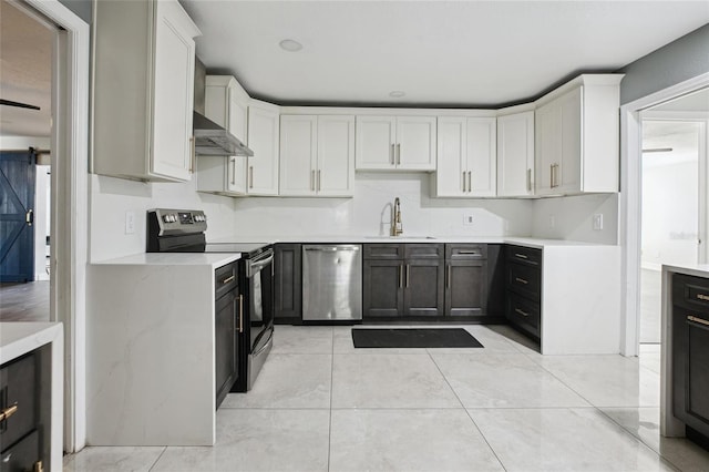 949 Shadow Oaks Rd, Kissimmee, FL 34744 - kitchen featuring stainless steel appliances, light countertops, wall chimney range hood, and white cabinets