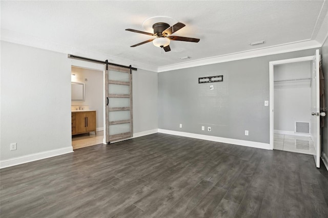 949 Shadow Oaks Rd, Kissimmee, FL 34744 - unfurnished living room with ceiling fan, a barn door, ornamental molding, and dark wood finished floors