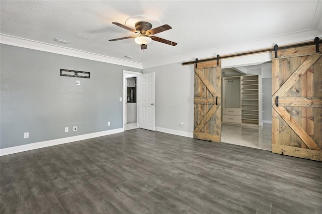 949 Shadow Oaks Rd, Kissimmee, FL 34744 - unfurnished living room with a barn door, ceiling fan, ornamental molding, and dark wood-style flooring