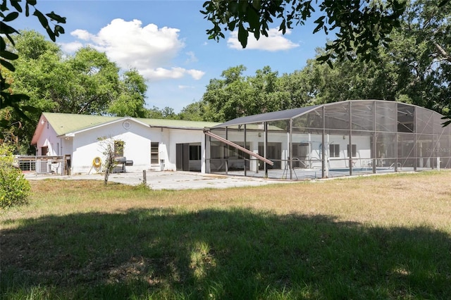 949 Shadow Oaks Rd, Kissimmee, FL 34744 - back of property featuring a patio area, a lawn, glass enclosure, and stucco siding