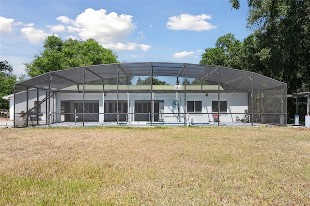 949 Shadow Oaks Rd, Kissimmee, FL 34744 - rear view of property featuring a lawn, a garage, and a lanai
