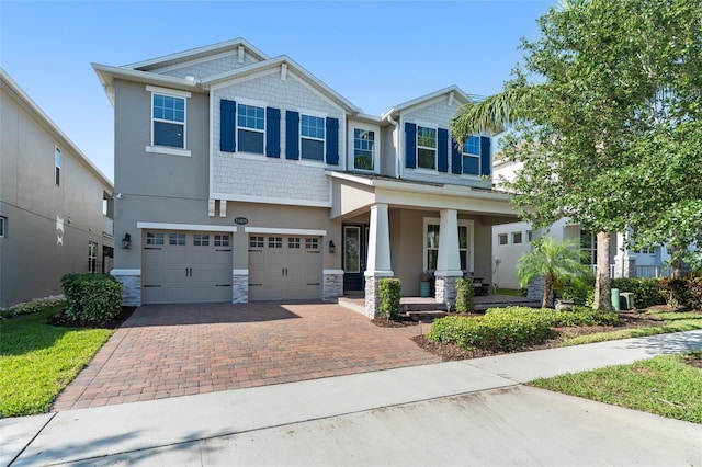 15420 Southern Martin St, Winter Garden, FL 34787 - craftsman-style house featuring covered porch, stone siding, decorative driveway, and an attached garage