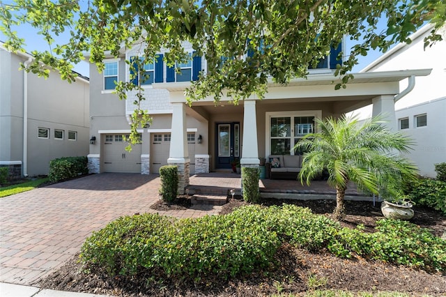 15420 Southern Martin St, Winter Garden, FL 34787 - view of front of property featuring a porch, decorative driveway, an attached garage, stucco siding, and stone siding