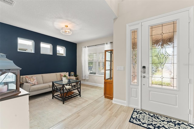 15420 Southern Martin St, Winter Garden, FL 34787 - entrance foyer featuring light wood-style flooring, baseboards, and a textured ceiling