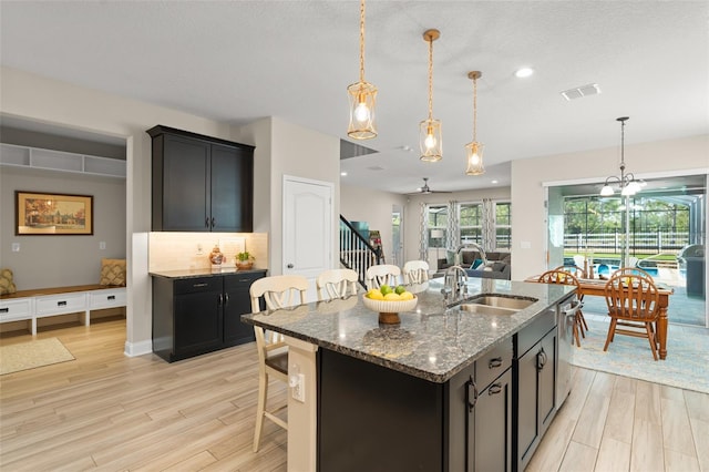15420 Southern Martin St, Winter Garden, FL 34787 - kitchen with a sink, light wood finished floors, dark stone countertops, hanging light fixtures, and recessed lighting