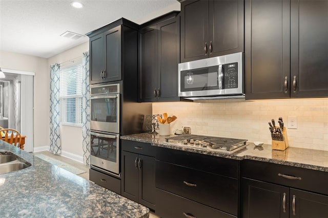 15420 Southern Martin St, Winter Garden, FL 34787 - kitchen with appliances with stainless steel finishes, backsplash, baseboards, and dark stone countertops