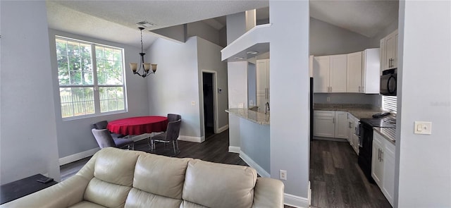 8612 Valley Ridge Ct, Orlando, FL 32818 - kitchen with black appliances, vaulted ceiling, a chandelier, white cabinetry, and open floor plan