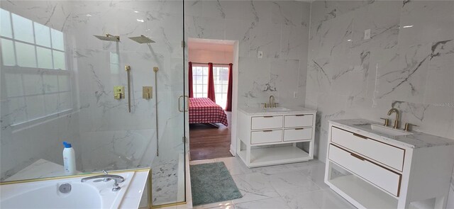 8612 Valley Ridge Ct, Orlando, FL 32818 - bathroom featuring a marble finish shower, marble finish floors, tile walls, vanity, and a bath