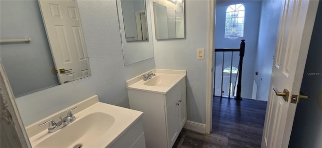 8612 Valley Ridge Ct, Orlando, FL 32818 - bathroom with wood finished floors, two vanities, and baseboards